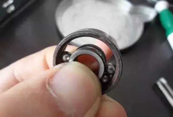 用手將軸承拿起，需要注意要向有滾珠的方向頂住